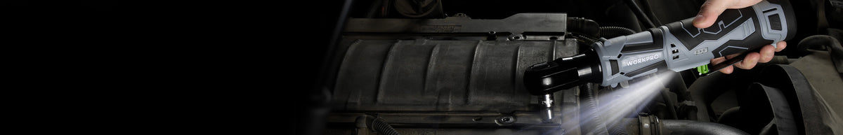 Cordless power drill with a black battery pack, held over a tool bag while its built in light illuminates the work area