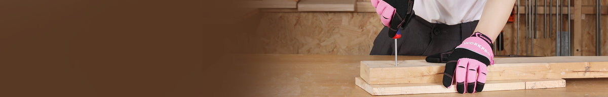 Person wearing pink gloves drills a wooden plank on a workbench in a wood workshop