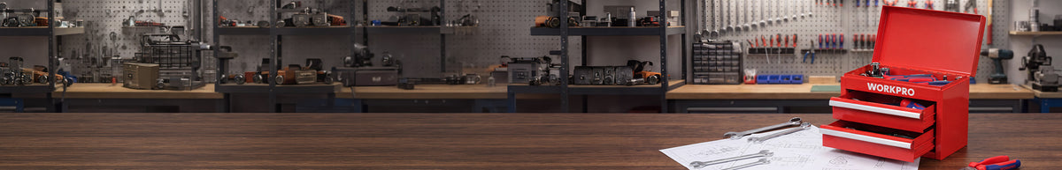 Workshop display with a red metal toolbox, tools on pegboards, and papers on a wooden workbench