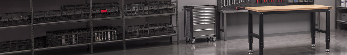 Industrial workshop with metal shelving, organized tools, a rolling drawer cabinet, and a black workbench