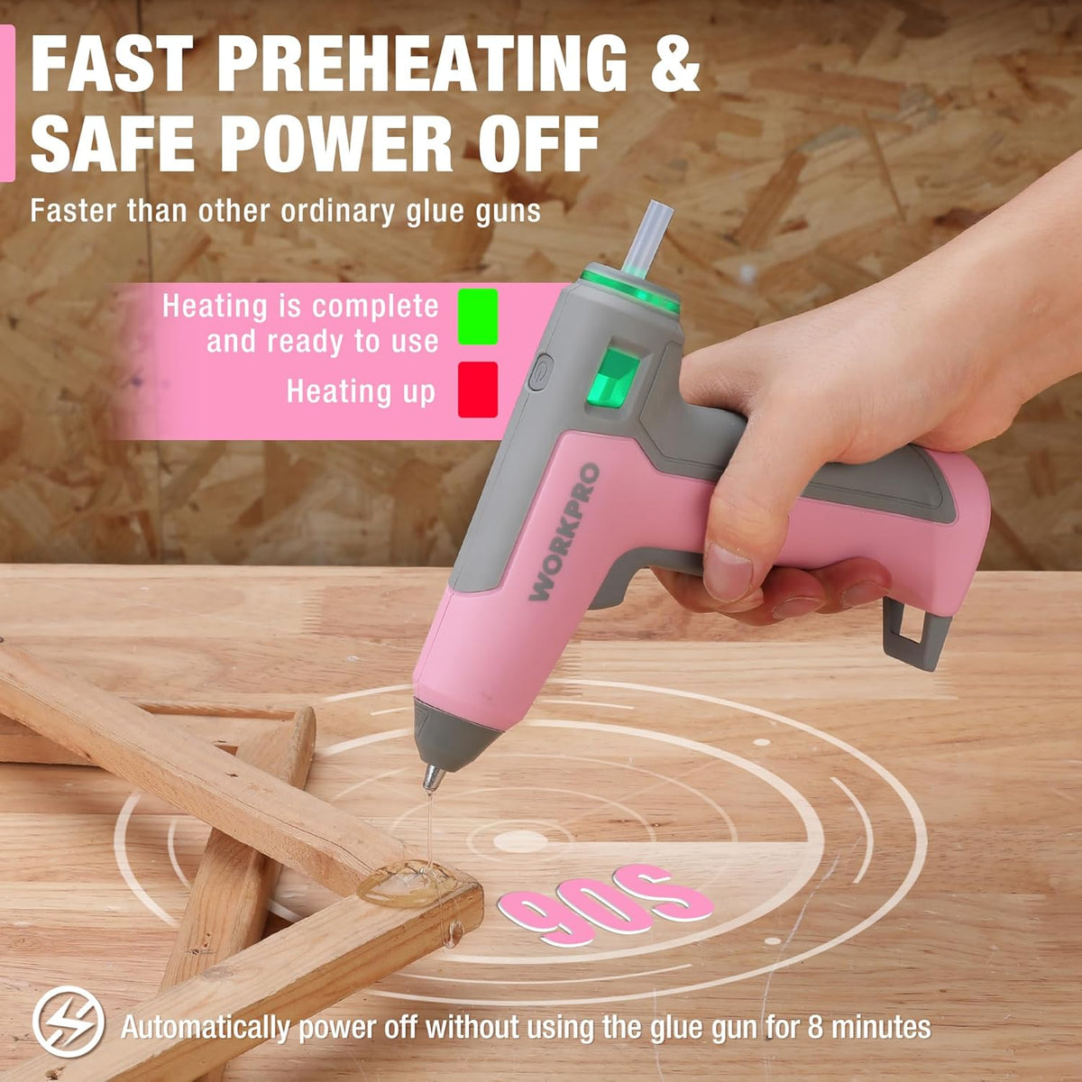 Pink cordless mini hot glue gun held in hand with gray handle and nozzle