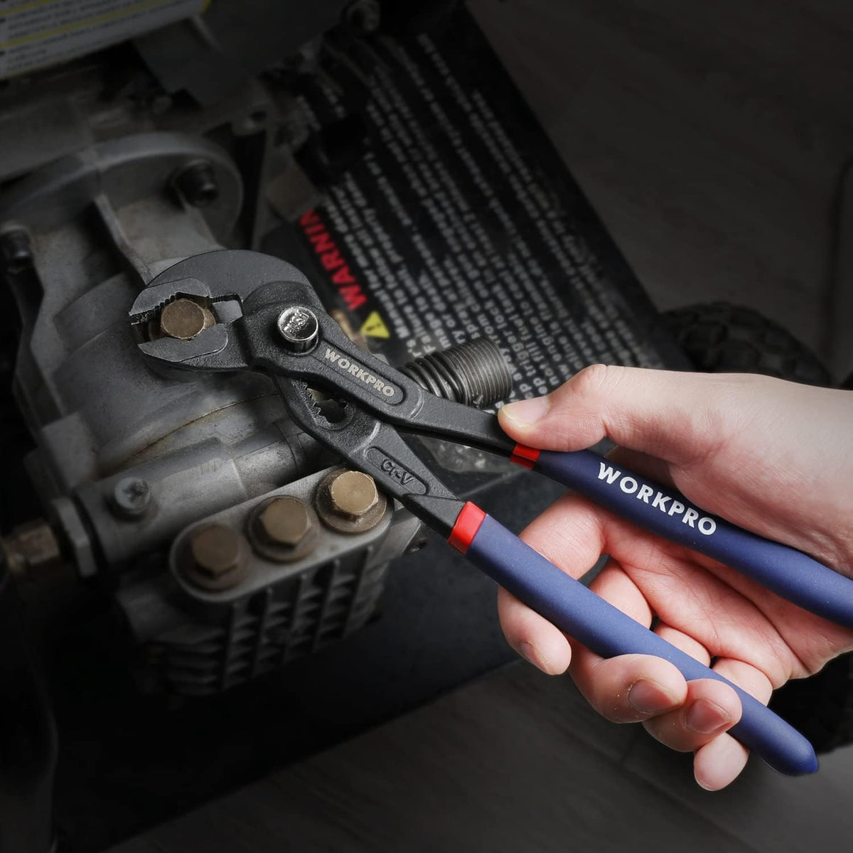 Groove joint pliers tightening a fitting in hand with blue handles