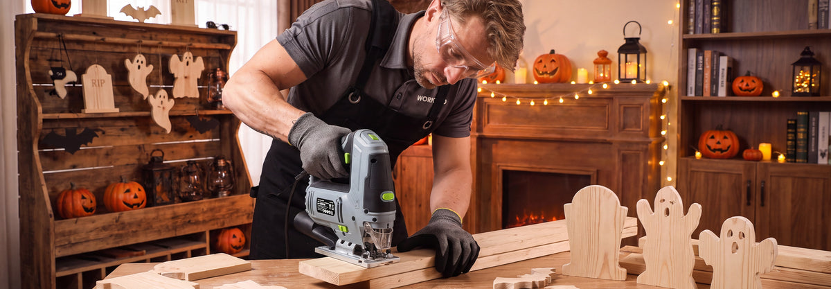 Woodworker using a jigsaw to cut wooden Halloween decorations in a workshop, with carved pumpkins and tools visible