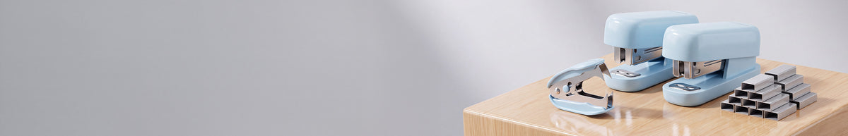 Small blue device with metal parts resting on a wooden box, shown against a plain light background
