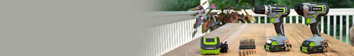 Cordless power tool set with two drills, batteries, chargers, and compact tools arranged on a wooden deck