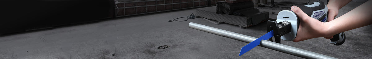 Outdoor floor cleaning machine with a long handle and rotating brush cleaning a paved surface