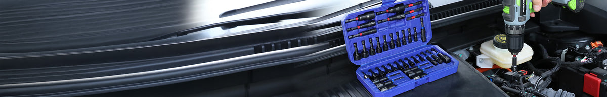 Blue mechanic tool set with socket case beside a cordless drill and vehicle engine components in a workshop