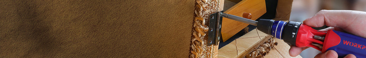 Close view of a red and blue handheld tool pressing against an ornate gold textured surface