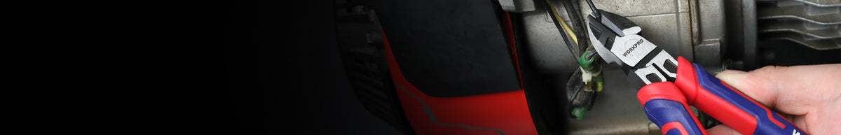 Red and blue automotive repair tools beside a black vehicle component, showing a compact workspace with visible metal