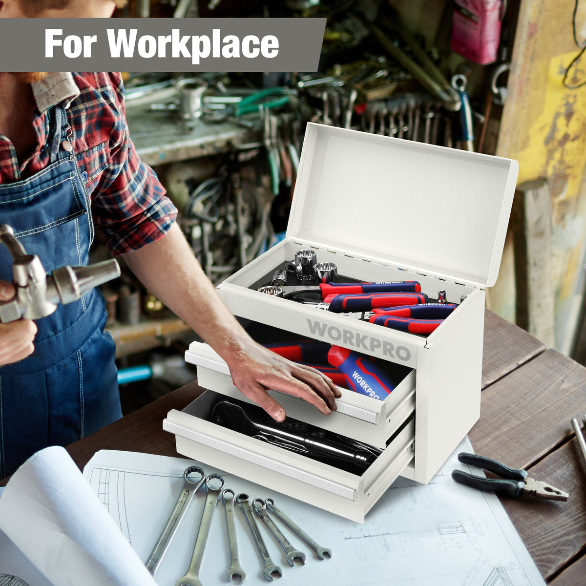 White mini metal tool box with open lid and two drawers holding tools