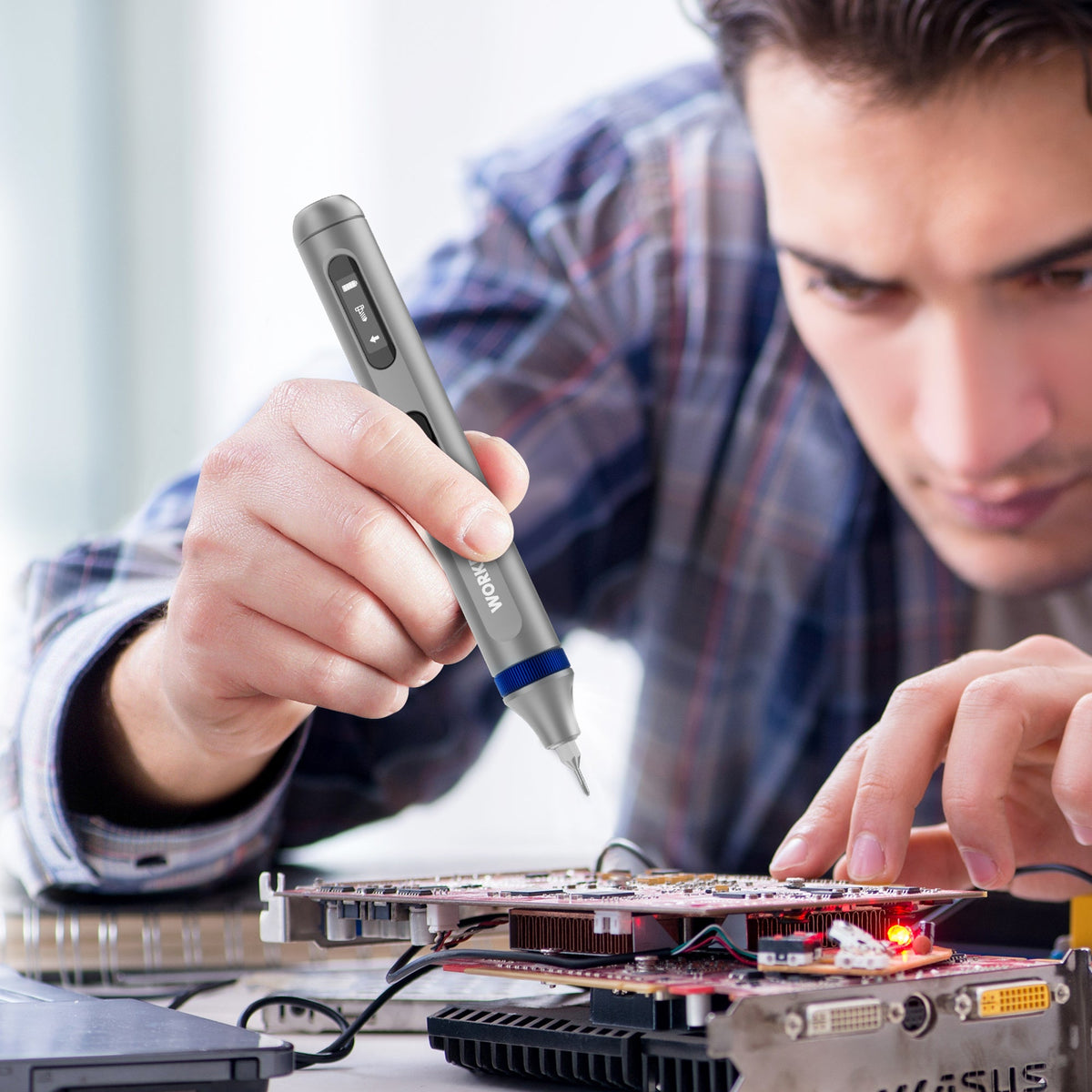 WORKPRO electric precision screwdriver in hand over circuit board components